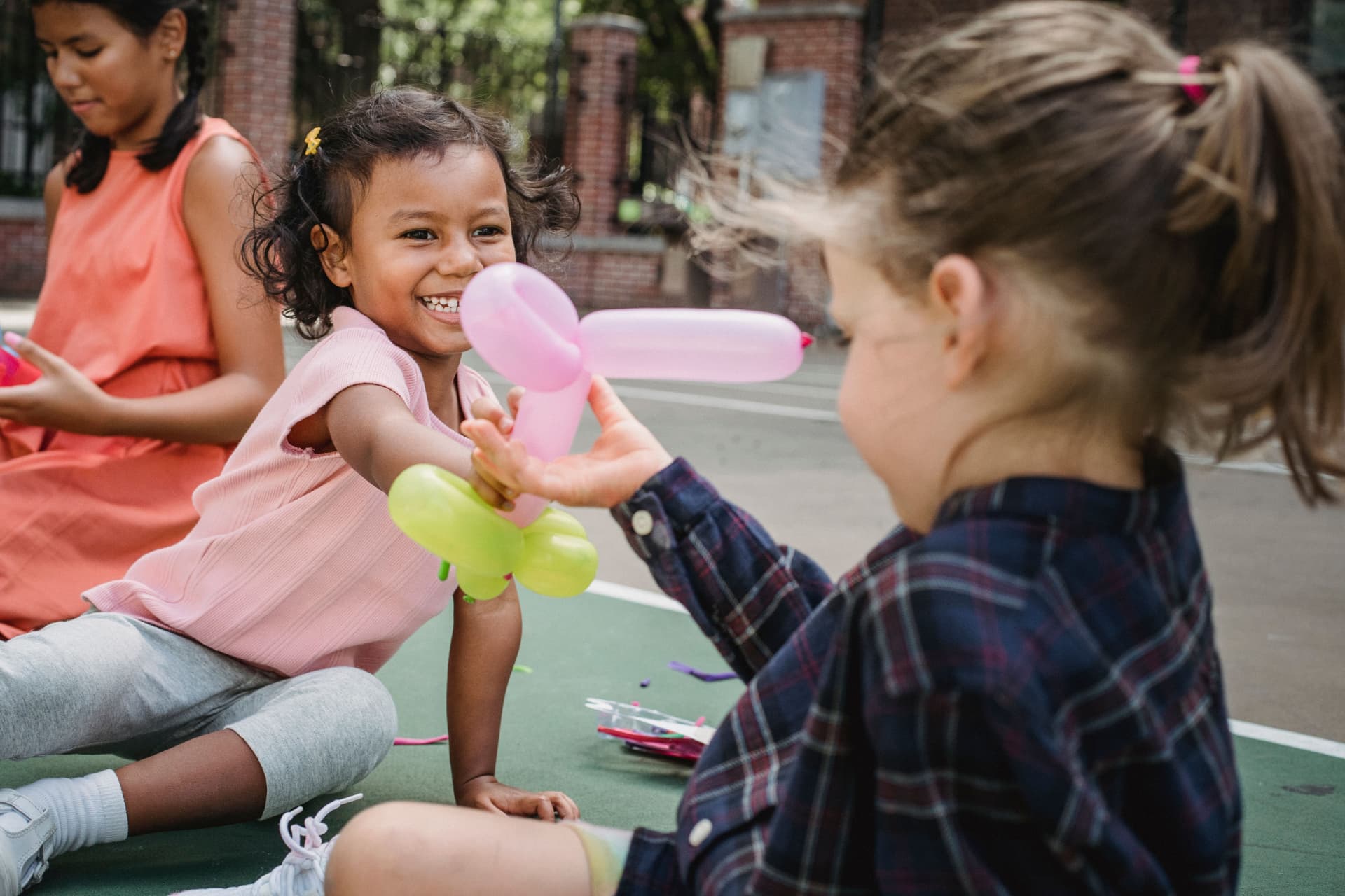 Children gathered around balloon animals at an outdoor event