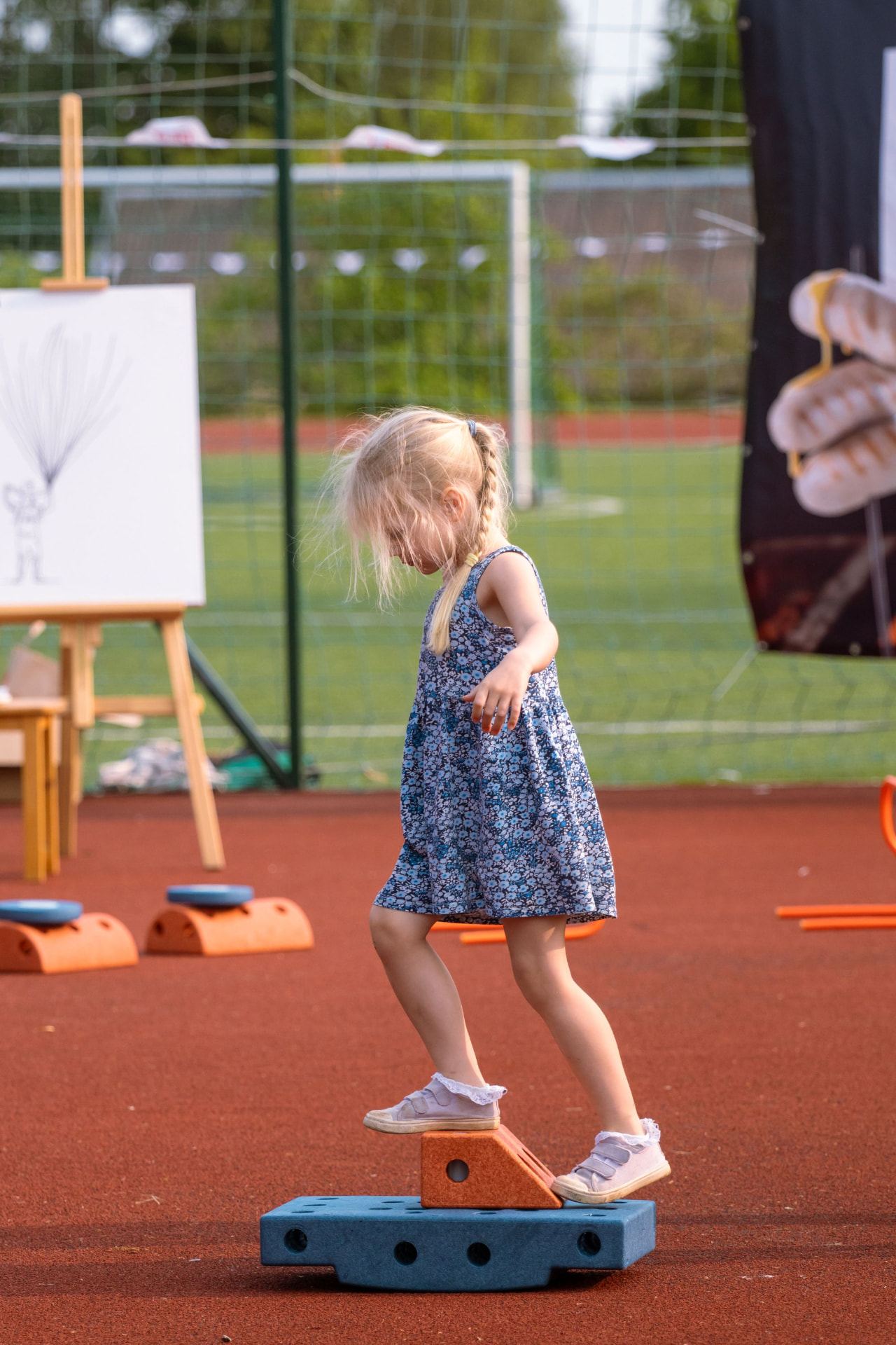 A young girl crossing a balance course on an outdoor playground