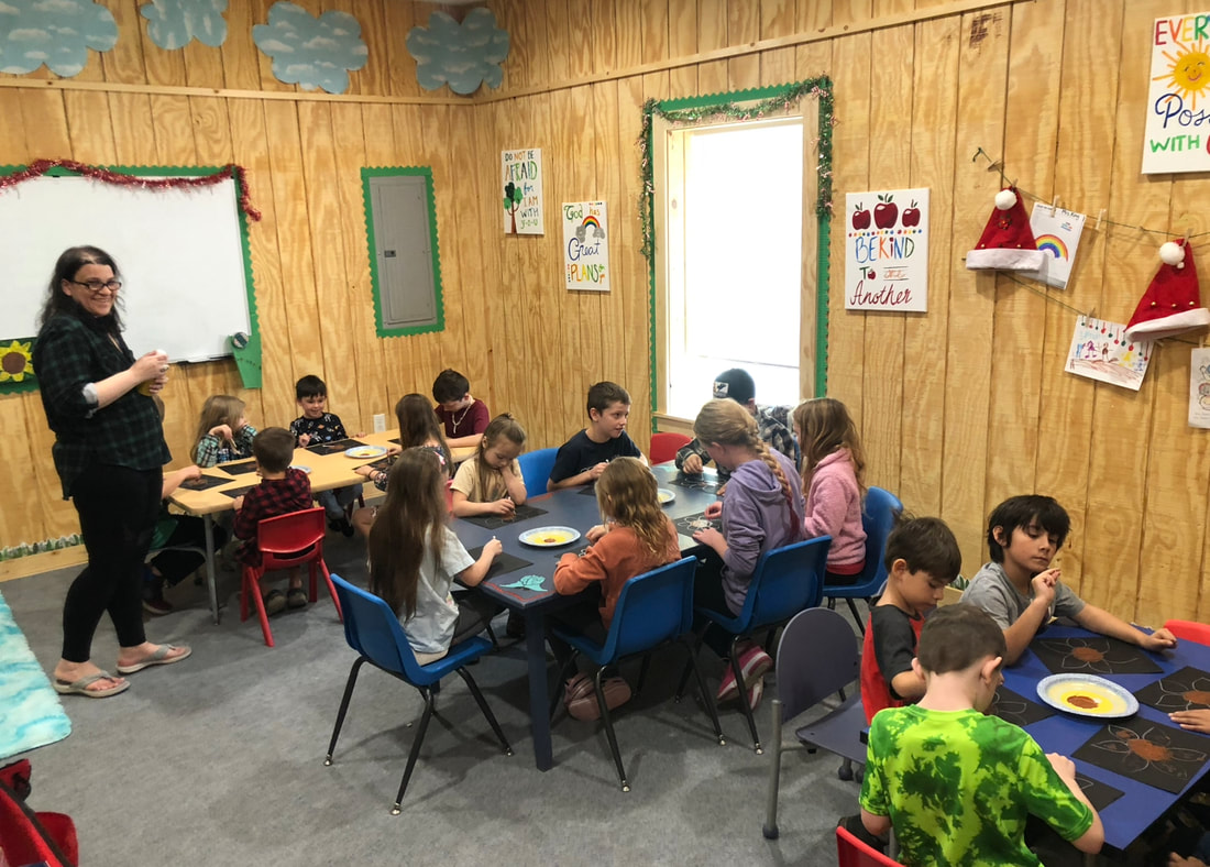 A full co-op classroom of kids working on an art project together