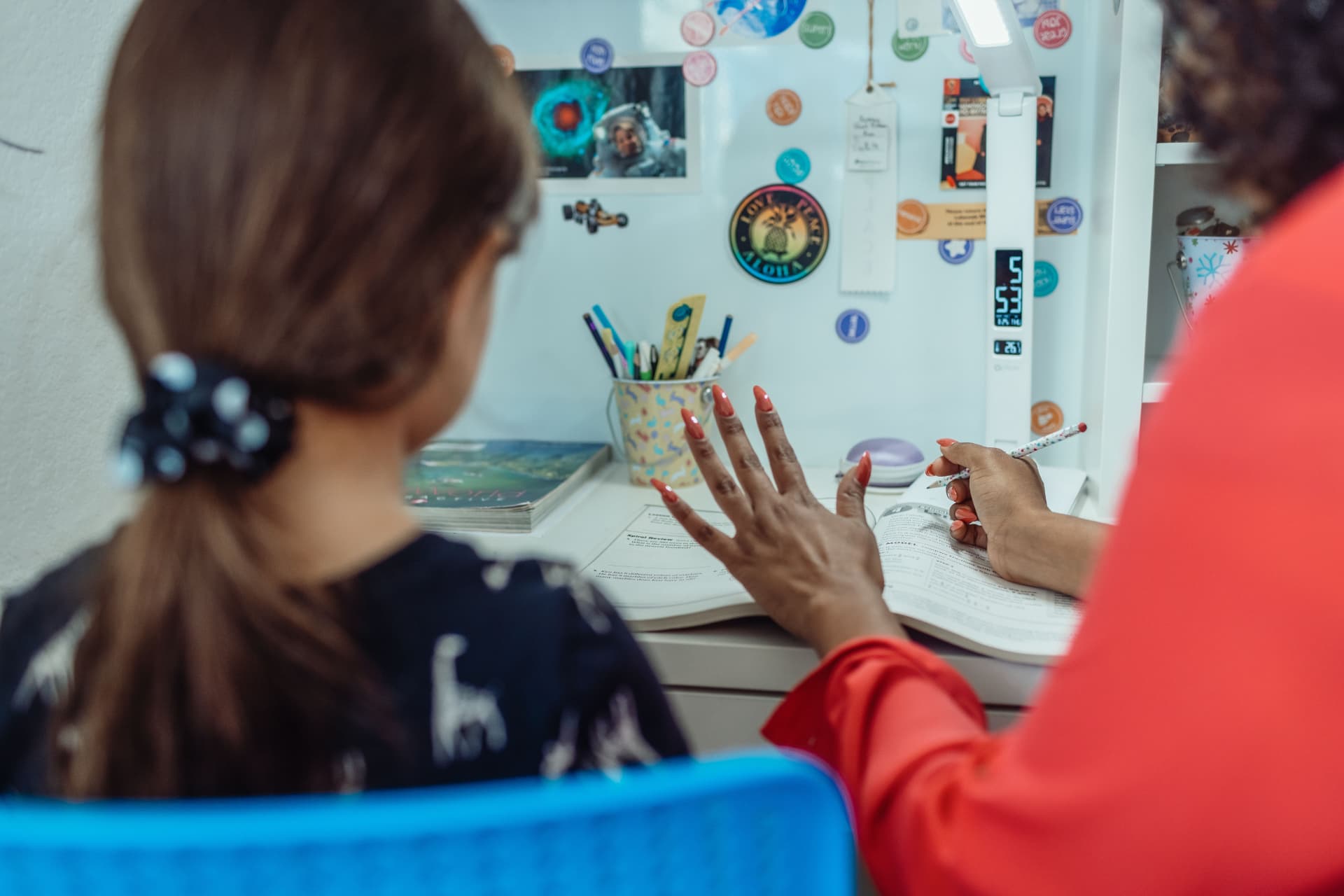 A tutor walking a student through a math lesson at her desk